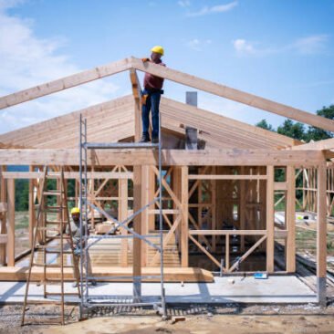 Builders working on wooden construction site, modern wooden house.
